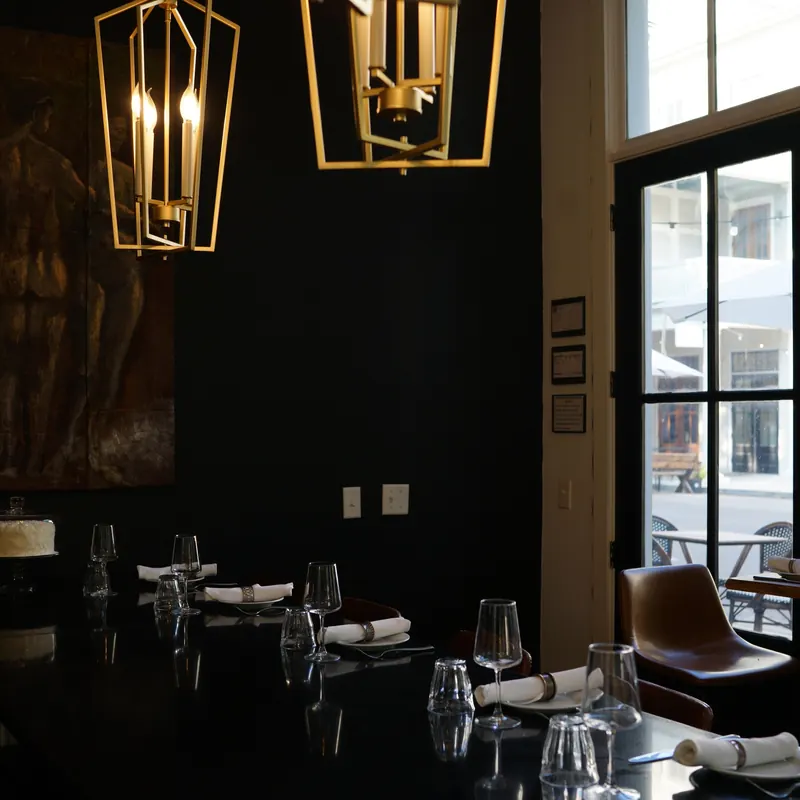 The dark dining room lit by hanging lanterns
