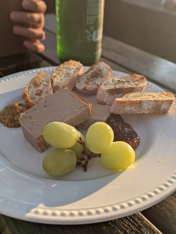 A truffle p&acirc;t&eacute; plate with grapes and toasted bread