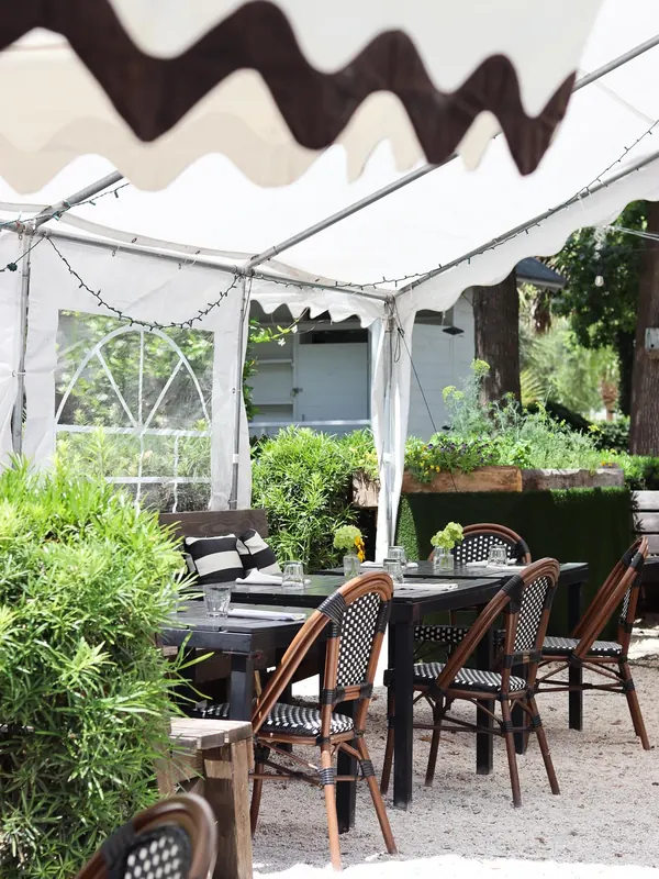 The covered patio at Bistro Ten with raised herb beds and bistro chairs