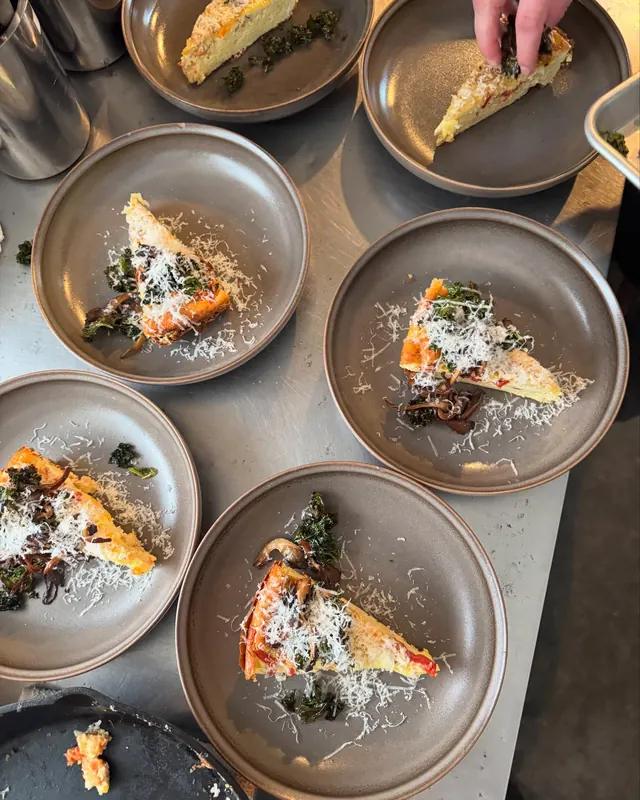 Plated salmon lined up at the pass in the kitchen