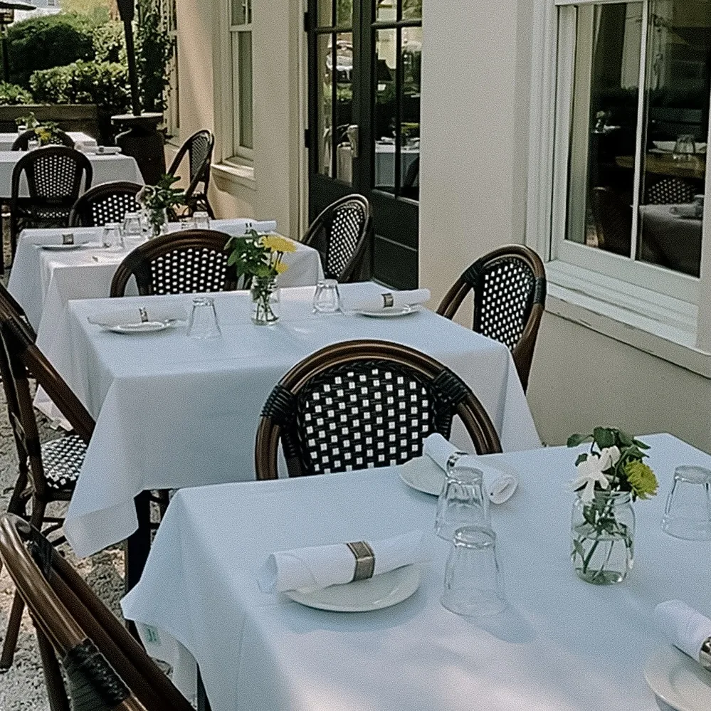 A table at Bistro Ten set with white linen, glassware and a bottle chilling in an ice bucket