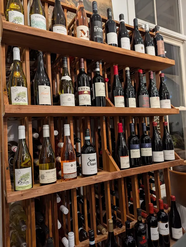 A wall of wine bottles on wooden shelves